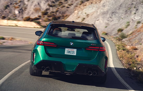 Rearview shot of a BMW M5 Touring driving down a mountainous road. | BMW of Palm Springs in Palm Springs CA