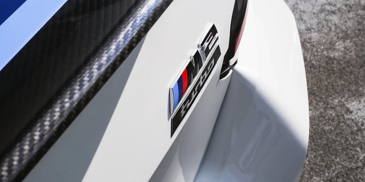 BMW M2 Turbo rear badge with carbon fiber trunk lip on Alpine White 2026 model.
