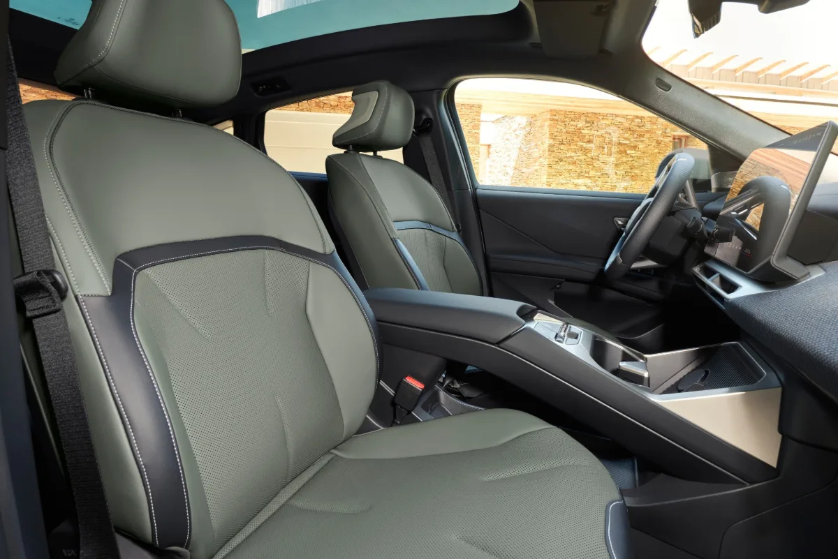 Front seats of the BMW iX4 50 xDrive with light gray upholstery.