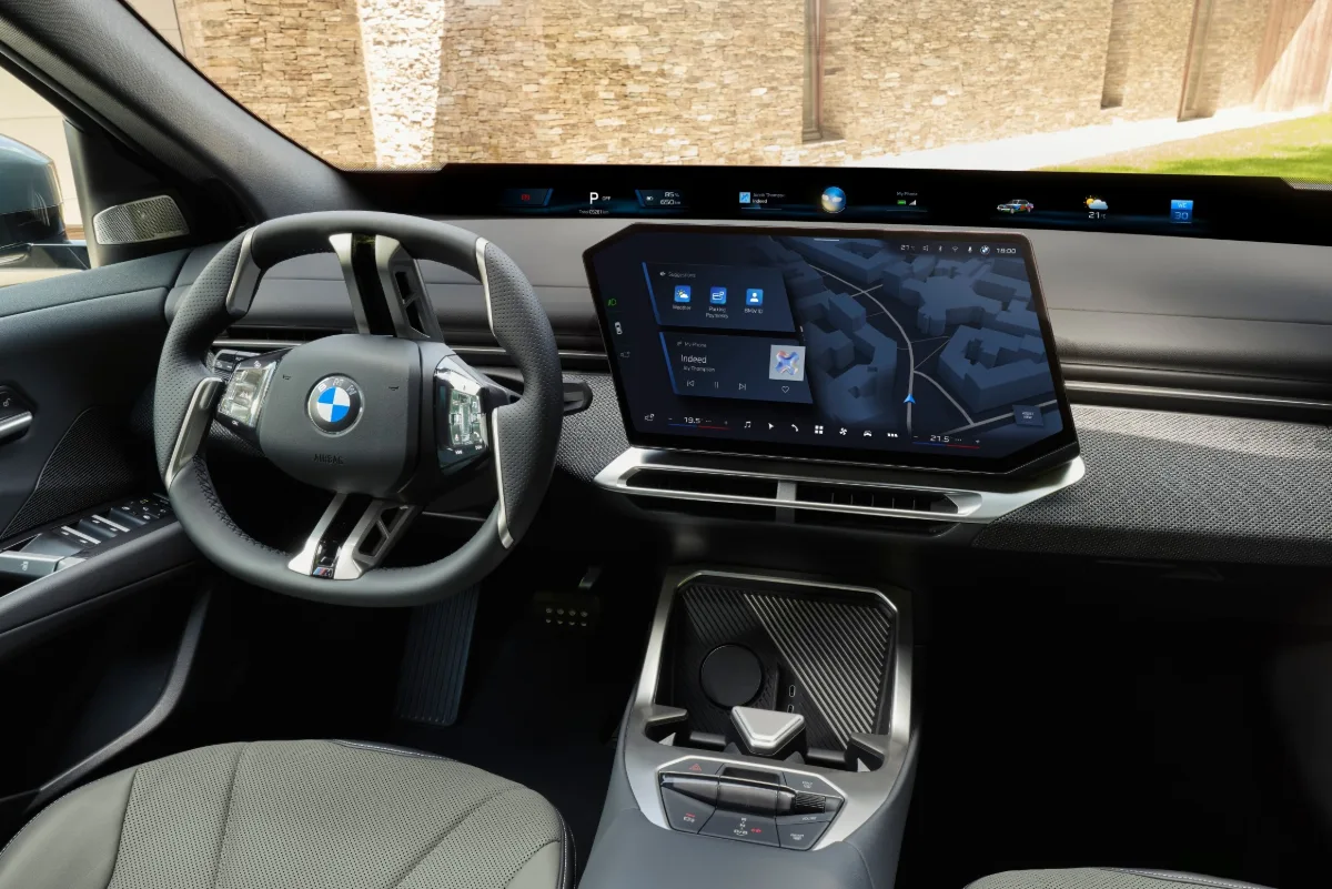 BMW iX4 50 xDrive cockpit with BMW Panoramic iDrive and central touchscreen.